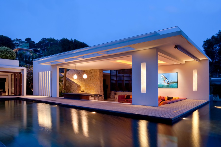 A beautifully illuminated open outdoor pool house.