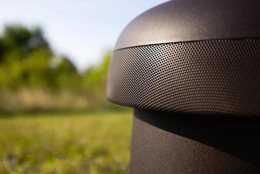 A Sonance outdoor audio speaker in focus outside.